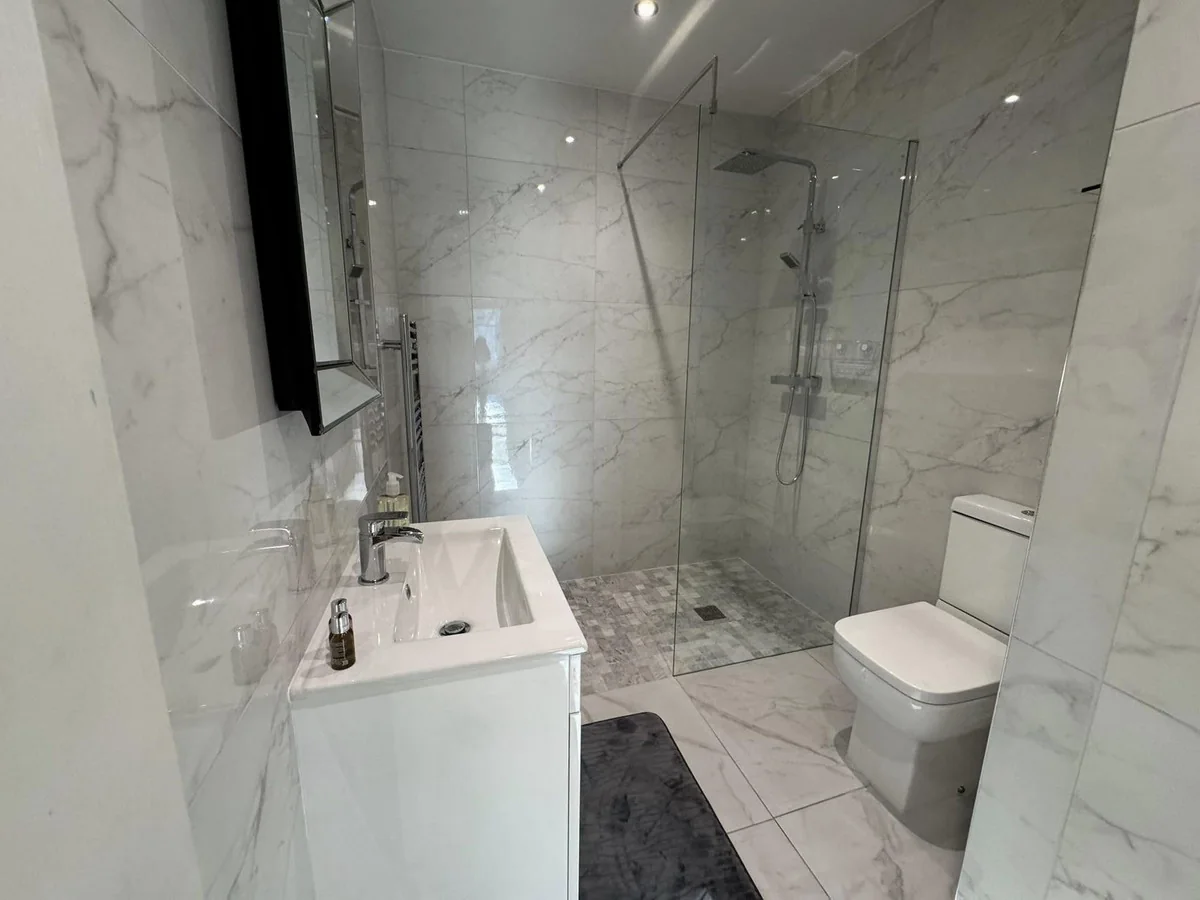 Designer bathroom with walk-in shower and marble-effect tiles